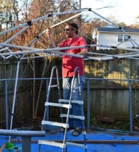 Richard stringing baling wire throughout the canopy frame