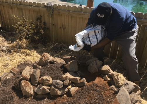 Pouring top soil into the herb spiral garden